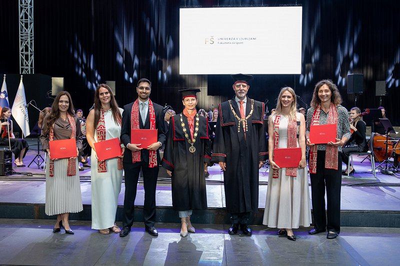 Promocija novih doktorjev znanosti Kristinr Drole, Lizr Jovičevič, Benjamina Naranga, Daše Pruš in Nike Šuc. V sredini z njimi stojita rektor UL prof. dr. Gregor Majdič in prodekanja za raziskovalno dejavnost UL FŠ prof. dr. Maja Pajek.